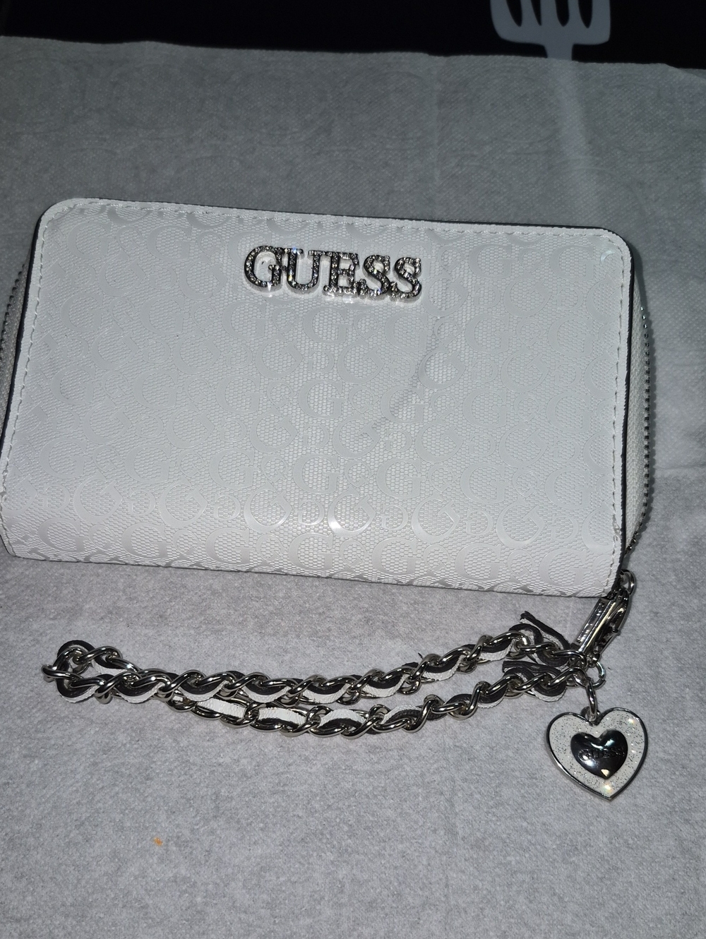 GUESS White Embossed Logo Wristlet with Silver Chain and Heart Charm